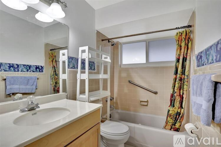 A bathroom with a toilet, sink, and bathtub.