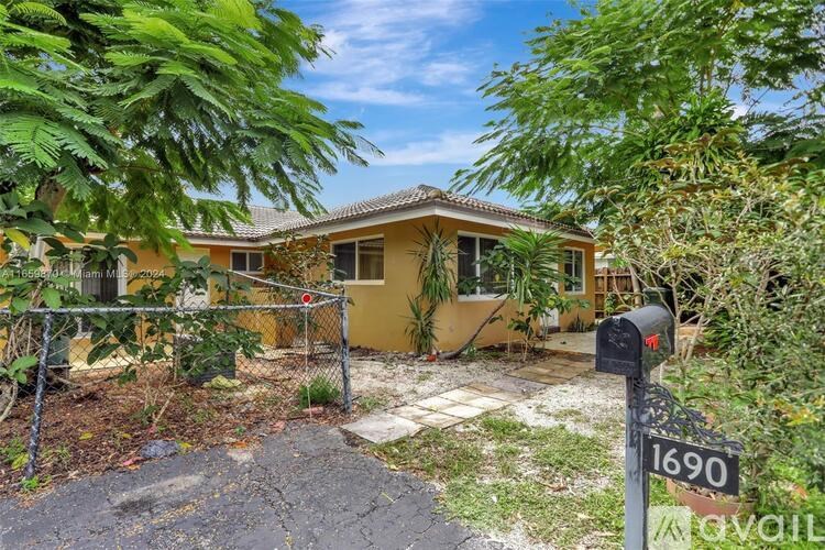 A yellow house with a mailbox number 1690 in front of it.