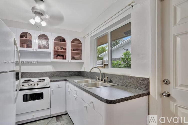 A kitchen with white appliances and cabinets.