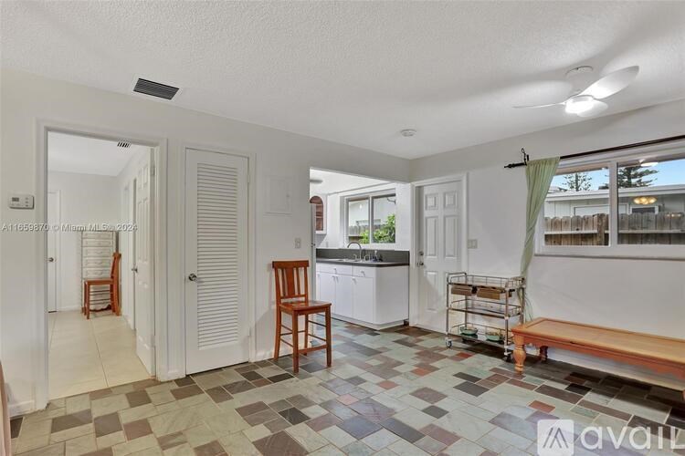 A kitchen with a tiled floor and a wooden chair.