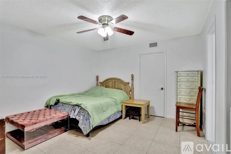A bedroom with a bed, bench, and chair.