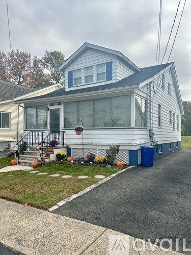 A blue and white house with a front porch and a small front yard.