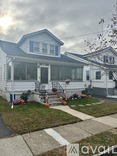 A house with a front porch and a white picket fence.