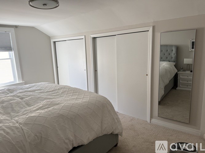 A bedroom with a large bed and a mirror on the wall.