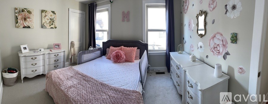 A bedroom with a bed, dresser, and mirror.