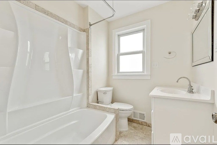 A white bathroom with a tub, toilet, and sink.