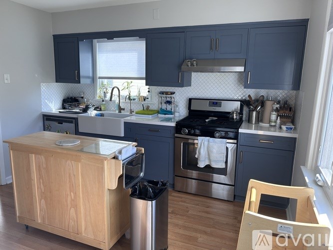 A kitchen with a wooden island and stainless steel appliances.