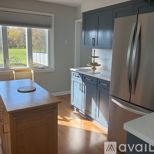 A kitchen with a wooden island and stainless steel appliances.