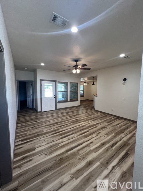 A room with wooden flooring and a ceiling fan.