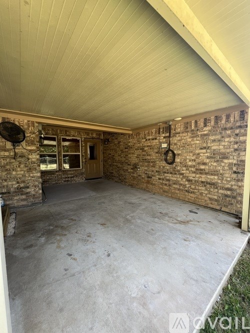 A room with a concrete floor and a brick wall.