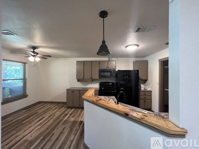 A kitchen area with a counter and a microwave.