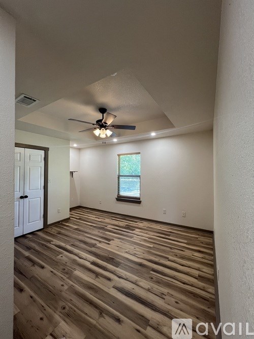 A room with wooden flooring and a ceiling fan.
