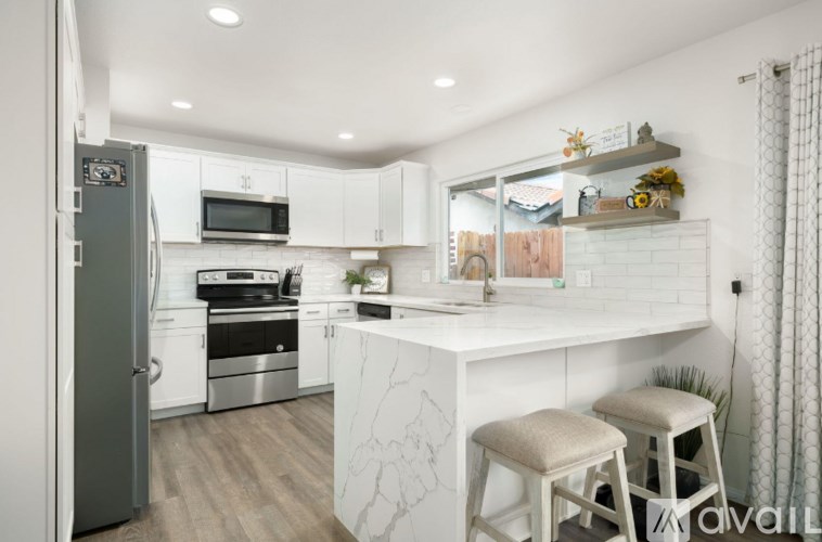 A kitchen with white cabinets and a white counter top.