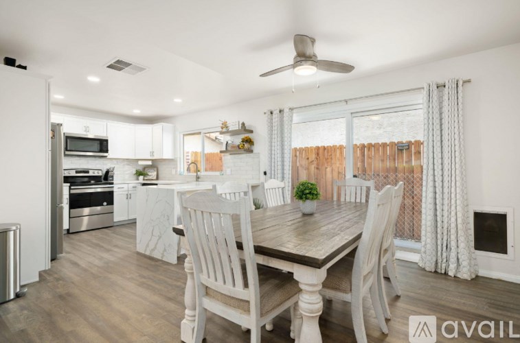 A kitchen with a table and chairs in front of a window.