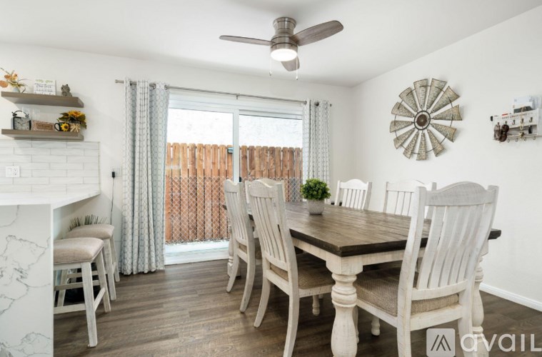 A dining room with a wooden table and chairs.