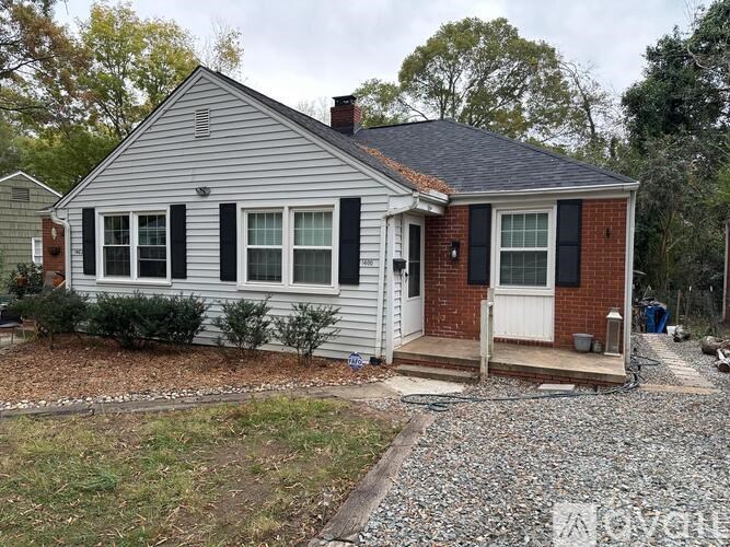 A small house with a white door and black shutters.