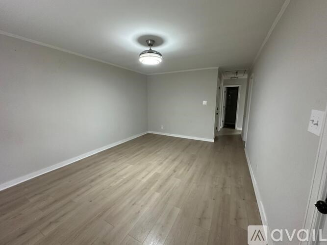 A room with wooden flooring and a ceiling light.