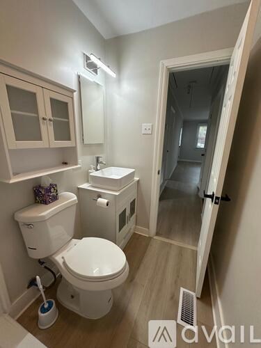A bathroom with a toilet, sink, and mirror.