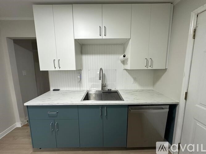 A kitchen with white cabinets and a blue island.
