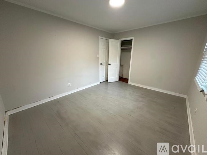 A room with a white door and a window with blinds.