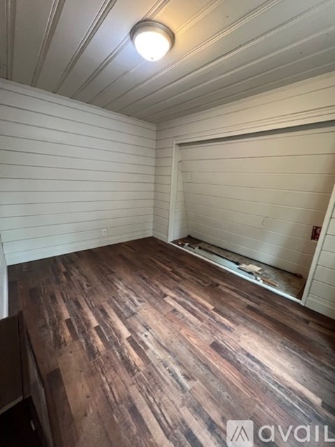 A room with wooden flooring and a white ceiling.