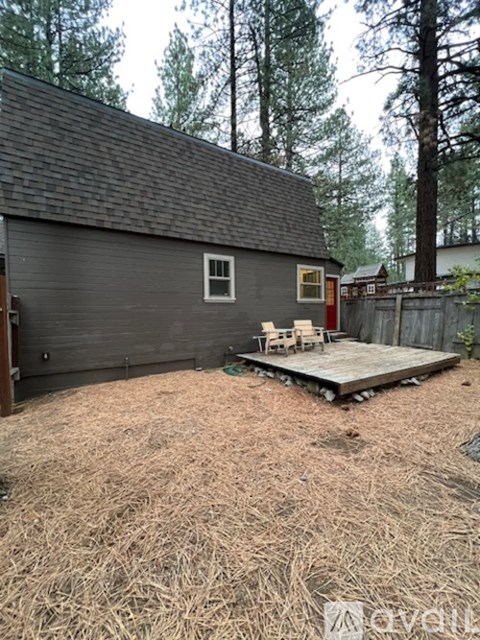 A grey house with a wooden deck in front.