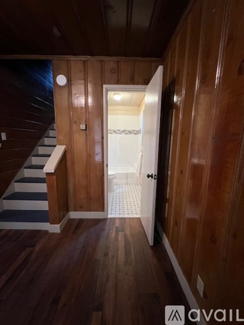 A hallway with wooden walls and a white door.