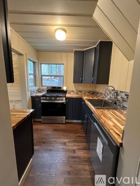 A kitchen with wooden floors and a stove top oven.