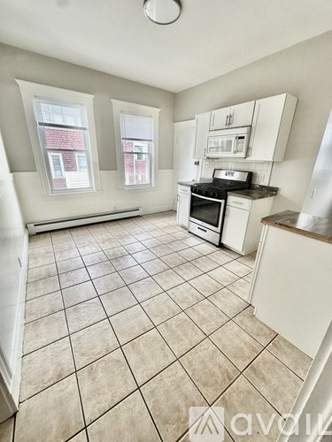 A kitchen with white cabinets and a black stove top oven.