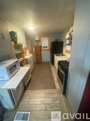A kitchen with a microwave, oven, and refrigerator.