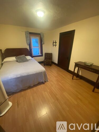 A bedroom with a bed, a chair, and a desk.