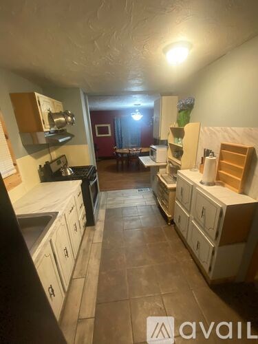 A kitchen with white cabinets and a black stove top oven.