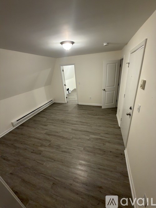 A room with wooden flooring and white walls.