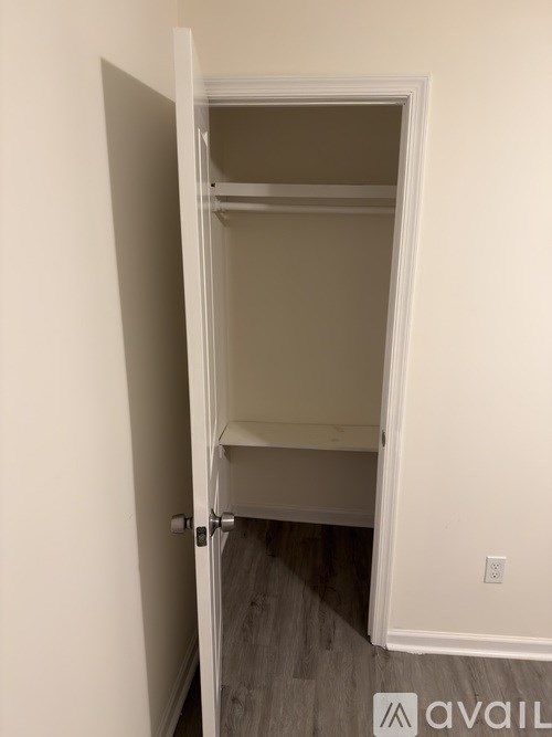 A white door is open to a small closet.