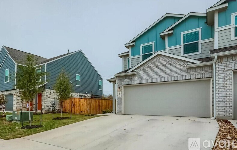 A house with a blue exterior and a white garage door.