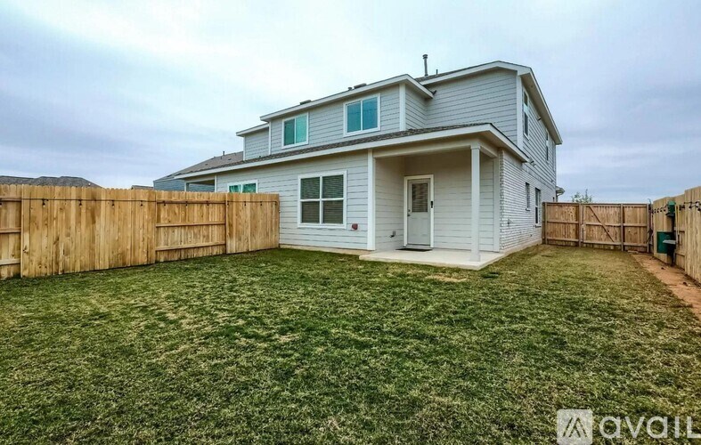 A house with a fence and a yard is available for rent.