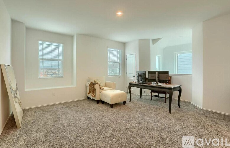 A spacious room with a desk, chair, and a window with blinds.