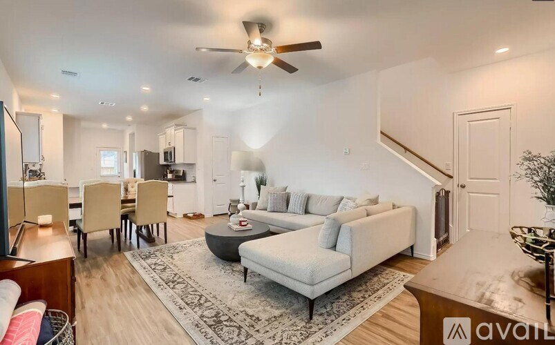 A living room with a couch, chairs, and a rug.