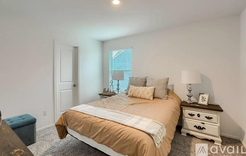 A bedroom with a bed, nightstand, and window.