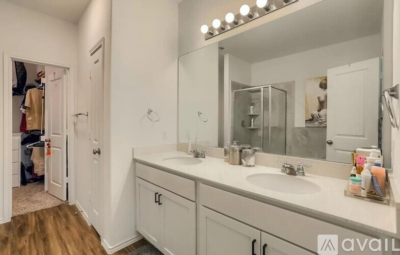 A bathroom with a large mirror and lights above it.