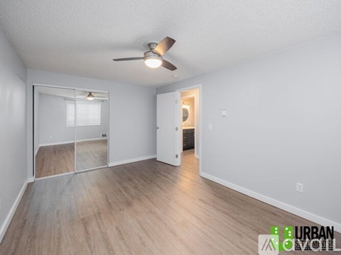 A room with a ceiling fan and a sliding glass door.