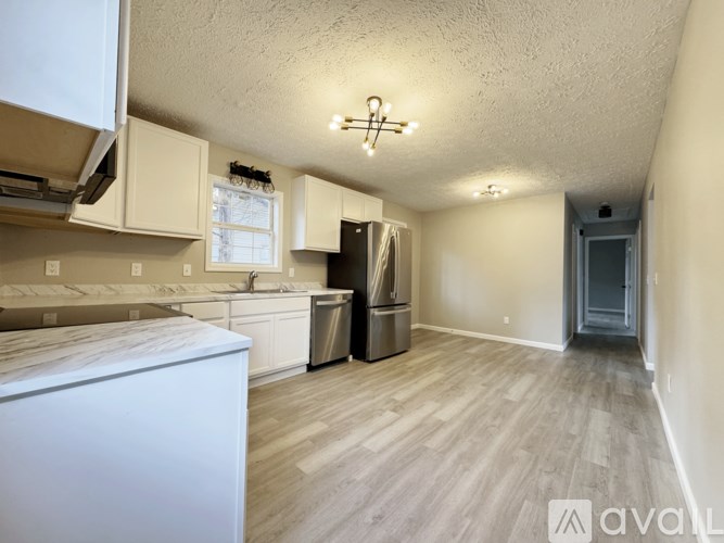 A kitchen with white cabinets and a white dishwasher.