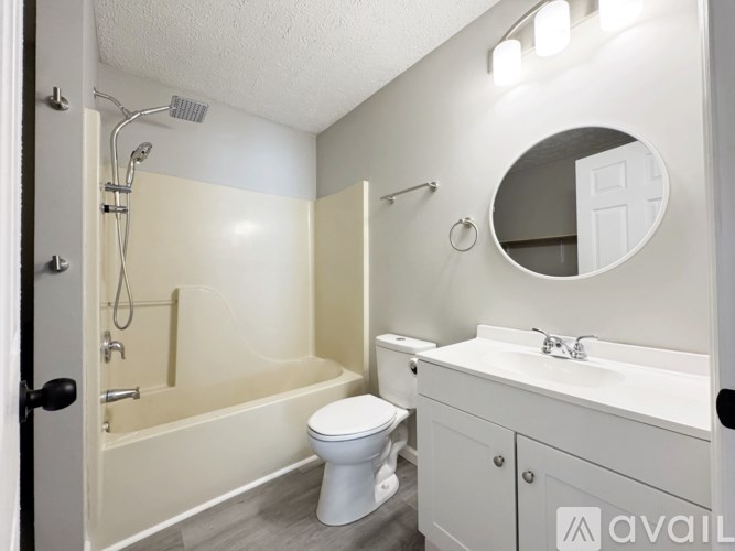 A bathroom with a toilet, sink, and shower.