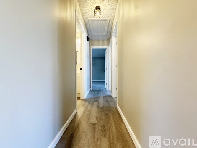 A long hallway with a blue door at the end.