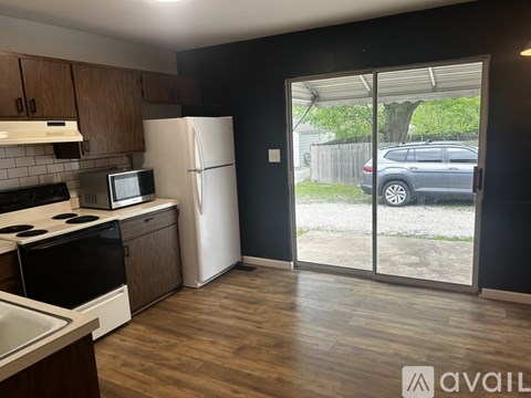 A kitchen with a white fridge and black stove top oven.