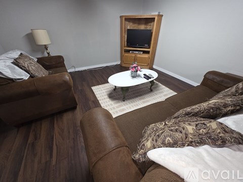 A living room with brown leather couches and a wooden entertainment center.