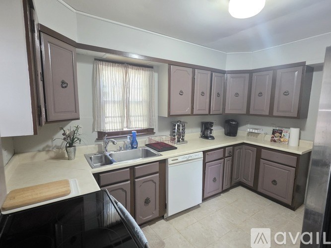 A kitchen with brown cabinets and a white sink.