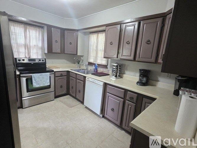 A kitchen with brown cabinets and a white dishwasher.