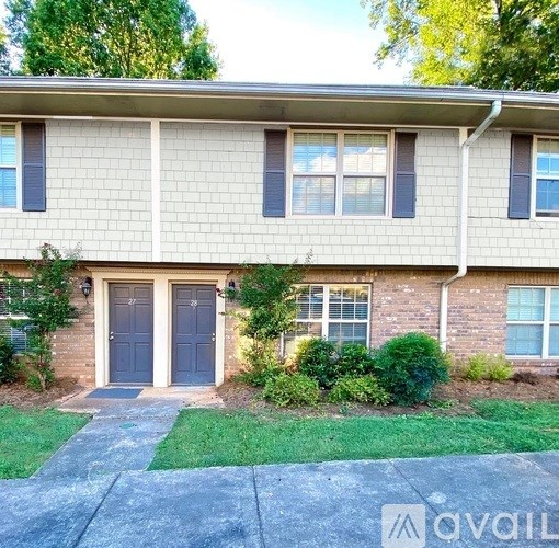 A house with a grey front door and a small garden in front.