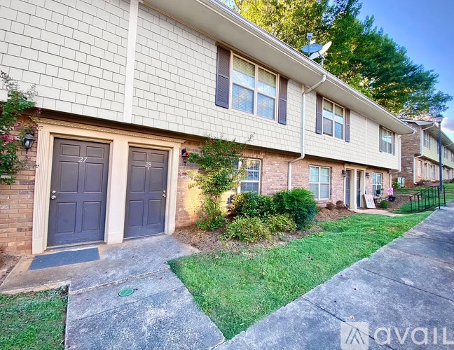 A house with a grey front door and a green lawn.